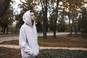 Man in hoodie walks through park wondering what a speedball is