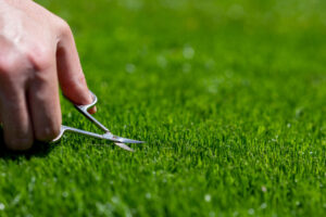 Man cuts grass, to represent connection between perfectionaism and addiction